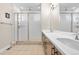 Well-lit bathroom featuring a double sink vanity, a frameless glass shower and tile floors at 11193 Mission Walk St, Parker, CO 80134