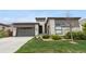 Contemporary home featuring a stone and siding exterior, a two-car garage, and manicured lawn at 11193 Mission Walk St, Parker, CO 80134