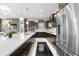 Modern kitchen featuring a large island, stainless steel appliances, and sleek dark wood cabinetry at 11193 Mission Walk St, Parker, CO 80134