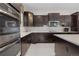 Well-equipped kitchen with dark cabinetry, stainless steel appliances, and a stylish backsplash at 11193 Mission Walk St, Parker, CO 80134