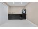 Basement wet bar features dark cabinetry, a sink, mini fridge, and modern white floors at 11193 Mission Walk St, Parker, CO 80134
