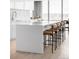 Modern kitchen island with bar stool seating and white backsplash at 3100 E Cherry Creek South Dr # 1201, Denver, CO 80209
