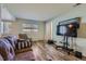 Bright living room with windows, wood floors, comfortable seating, and a mounted television at 3354 S Flower St # 14, Lakewood, CO 80227