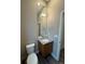 Cozy half-bathroom featuring a granite countertop, undermount sink, a mirror, and a toilet at 9715 Taylor River Cir, Littleton, CO 80125