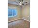 Well-lit bedroom with neutral walls, carpet floors, and a window overlooking the basement entrance at 9715 Taylor River Cir, Littleton, CO 80125