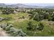 Expansive aerial shot capturing the serene acreage property, enhanced by views of distant mountains and lush greenery at 12196 W Belleview Dr, Littleton, CO 80127
