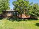 Backyard featuring a well-maintained lawn, deck, and mature trees at 12196 W Belleview Dr, Littleton, CO 80127