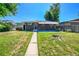 Well-maintained backyard and home featuring dark brick and a small awning at 7011 Poplar St, Commerce City, CO 80022