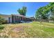 Backyard view of home with dark brick and fenced yard at 7011 Poplar St, Commerce City, CO 80022