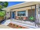 Inviting front porch with wrought iron details, seating, a view of the garden, and a blue front door at 7011 Poplar St, Commerce City, CO 80022