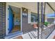Welcoming front porch featuring seating, garden views, decorative black wrought iron, and a bright blue door at 7011 Poplar St, Commerce City, CO 80022