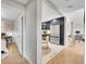Bright interior of the home with hardwood floors, navy blue kitchen, and access to other rooms at 7011 Poplar St, Commerce City, CO 80022