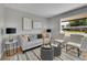 Cozy living room featuring modern decor, neutral paint, and a large window at 7011 Poplar St, Commerce City, CO 80022