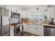 Modern white kitchen with stainless steel appliances and wood countertops at 4732 Lincoln St, Denver, CO 80216