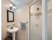 Stylish bathroom featuring a glass-enclosed shower, pedestal sink, and modern lighting fixtures at 2609 S Dahlia St, Denver, CO 80222