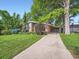 View of the house, driveway, and covered parking, nestled among mature trees and lush landscaping at 2609 S Dahlia St, Denver, CO 80222