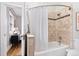 Bathroom featuring shower over tub with decorative tile, a curtain and a window at 2318 S Lincoln St, Denver, CO 80210