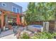 Backyard patio with hot tub, pergola, outdoor seating, and lush greenery at 3931 Utica St, Denver, CO 80212