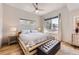 Bright bedroom with a log-style bed frame, tufted ottoman, and ample natural light at 3931 Utica St, Denver, CO 80212