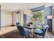Dining area with a glass table and four chairs next to a bright window looking out to the yard at 3931 Utica St, Denver, CO 80212