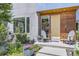 Front porch with comfortable chairs and a modern door with wood detailing and manicured landscaping at 3931 Utica St, Denver, CO 80212