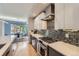 Chef's kitchen with stone backsplash, stainless appliances, eat in island and dining area nearby at 3931 Utica St, Denver, CO 80212