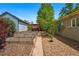 Spacious backyard featuring garden beds, stone walkway, and mature trees at 5573 S Datura St, Littleton, CO 80120