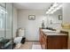 Bathroom with tiled floors, a single sink vanity and a framed mirror at 5573 S Datura St, Littleton, CO 80120