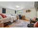 Cozy bedroom with wood floors, rug, seating area, desk, and two large windows with natural light at 5573 S Datura St, Littleton, CO 80120