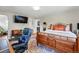 Spacious bedroom with wood floors, accent rug, seating area, desk, and access to a closet at 5573 S Datura St, Littleton, CO 80120