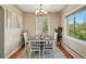 Bright dining room featuring a chandelier, a large window, and a dining set for six at 5573 S Datura St, Littleton, CO 80120