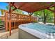 Outdoor hot tub under a pergola, next to backyard deck and home at 5573 S Datura St, Littleton, CO 80120
