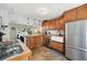 Open kitchen features tile floors, updated cabinets and stainless appliances, including range, sink and fridge at 5573 S Datura St, Littleton, CO 80120