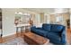 Living room view with seating, open kitchen with bar, hardwood floors, and view of a dining area in the distance at 5573 S Datura St, Littleton, CO 80120