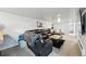Bright living room with a leather sofa, coffee table and gray carpet at 5573 S Datura St, Littleton, CO 80120