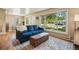 Comfortable living room with a large window, blue sofa, and view of the dining area at 5573 S Datura St, Littleton, CO 80120
