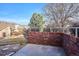 Brick patio with concrete floor and metal railing in front of green space and some trees at 2132 S Scranton Way, Aurora, CO 80014