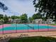 View of community tennis courts with green and pink surfaces and surrounding well-maintained landscaping at 2132 S Scranton Way, Aurora, CO 80014