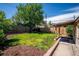 Backyard featuring a well-manicured lawn, mulch beds and a covered patio at 5549 S Greenwood St, Littleton, CO 80120