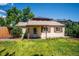 Fenced backyard with lush grass that shows a charming home with brown shutters and a solar paneled building at 5549 S Greenwood St, Littleton, CO 80120
