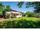 Large, grassy backyard featuring charming home with brown shutters, green trees and a solar paneled building at 5549 S Greenwood St, Littleton, CO 80120