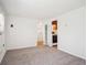 Bright bedroom featuring neutral carpet and fresh paint, with a doorway view to a laundry area at 5549 S Greenwood St, Littleton, CO 80120