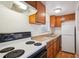 Efficient kitchen featuring wooden cabinets, a gas range, a stainless steel sink, and a new refrigerator at 5549 S Greenwood St, Littleton, CO 80120