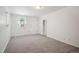 Clean and bright living room with neutral carpet, fresh paint, and an exterior access door at 5549 S Greenwood St, Littleton, CO 80120