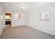 Bright living room featuring neutral carpet, fresh paint, and a kitchen pass-through window at 5549 S Greenwood St, Littleton, CO 80120