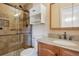 Updated bathroom features granite countertop, wooden vanity, and a glass shower with a rainfall showerhead at 12531 W Alameda Dr, Lakewood, CO 80228