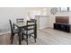 Bright dining area featuring stylish table set, gray plank floors, and a kitchen bar in the background at 18661 E Water Dr # F, Aurora, CO 80013