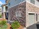 Exterior view of stone-clad building with landscaping, A/C unit and single-car garage at 18661 E Water Dr # F, Aurora, CO 80013
