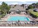 Community pool surrounded by lounge chairs, tables, umbrellas, and a decorative fence at 18661 E Water Dr # F, Aurora, CO 80013