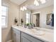 Modern bathroom with double vanity, large mirror, and updated fixtures at 9902 Cathay St, Commerce City, CO 80022